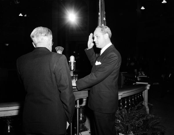 Governor Walter Kohler taking the oath of office on the balcony of the Wisconsin State Capitol rotunda. The oath was administered by Chief Justice Oscar M. Fritz of the State Supreme Court.