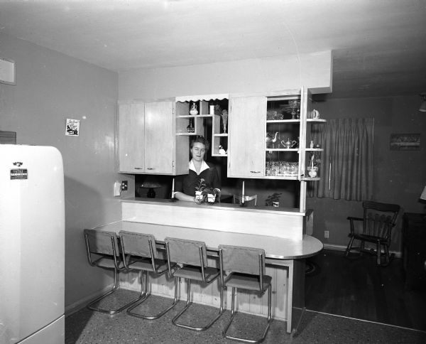 Kitchen designer Dorothy Flicek is standing behind a kitchen room divider she designed for her home, located at 3829 Ridgeway Avenue.