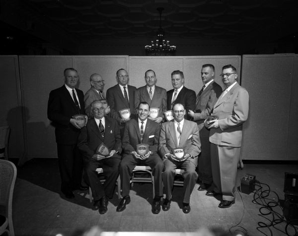 A group portrait of ten men holding awards.