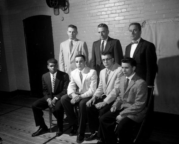 Group portrait of four athletes and three coaches. Shown left to right, they are: (front) Al Smith, football captain; Russ Allen, basketball captain; and Keith Breidung, and Jerry Martin, co-captains of the wrestling team. Standing in the back are: Robert Alwin, basketball coach; Harold (Gus) Pollock, football coach; and Sam Barosko, wrestling coach.