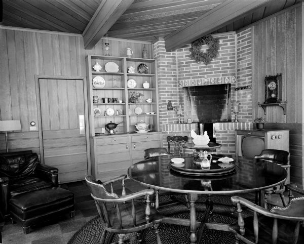 The family room of the Floyd and Marian Voight at 8 Fuller Court in Madison. The room features driftwood paneling, cork tile floor with braided rugs, and a corner fireplace.