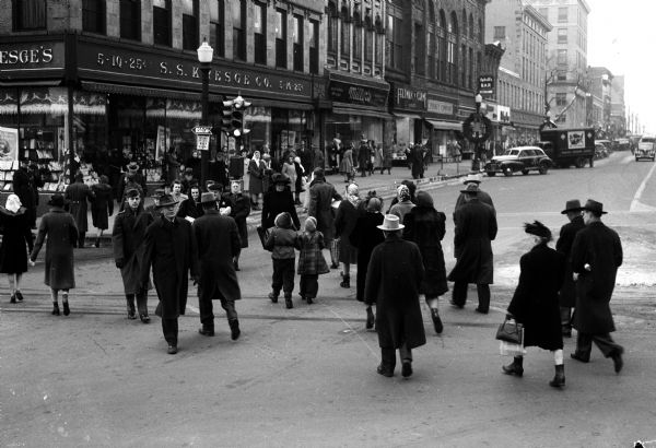 Christmas shoppers cross the the corner of King Street on the Capitol Square in front of Kresge's, 25-27 East Main Street.