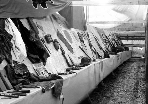 Display of German "war junk," including fire arms and clothing, exhibited at the East Side Business Men's Festival. The souvenirs on display were collected by 80 servicemen.