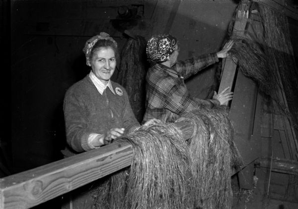 Two women processing hemp fibers at the DeForest hemp mill during World War II.
