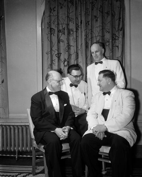 R. Roy Keaton, G.I. Wallace, Emil Schaefer, and Clarence Sturm wear formal dinner dress while celebrating the 35th anniversary of Madison's Lions Club.