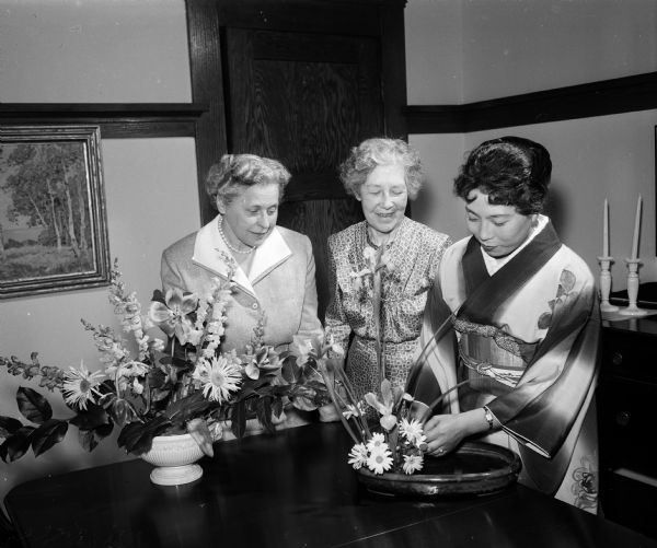 Makita Tomita (right), a native of Tokyo, Japan, demonstrating basic Japanese flower arrangement. Looking on at left, are Altrusa Club members Janet Jennings and Julia Grady.