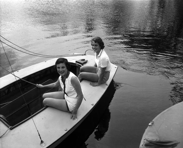 Jean Whiffen and Marilyn Tormey pose for a portrait in a sailboat.