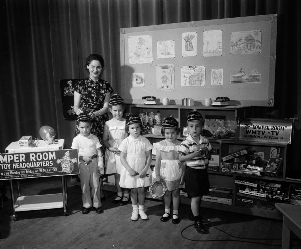 The set of WMTV's Romper Room program, showing "Miss Nancy" (Eunice Spindler) with her kindergarten "pupils."  They include, from left: David Shwaiko, Margaret Draper, Mary Gmeinder, Susan Draper, and Daniel Orvick.