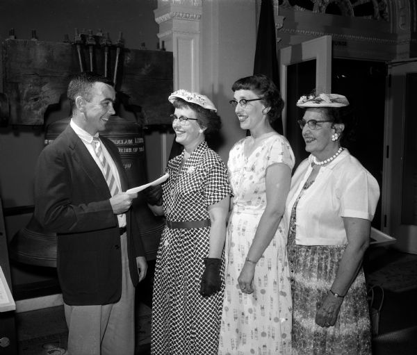 Three members of the Dane County Veterinary Association auxiliary presenting a check to Don McNeil, associate director of the State Historical Society, to be used to write a history of veterinary medicine in Wisconsin. The women, left to right, are Mrs. S.B. Hitchner of Middleton, Mrs. Joel Lillesand of Verona, and Mrs. Armin Krohn of Madison.
