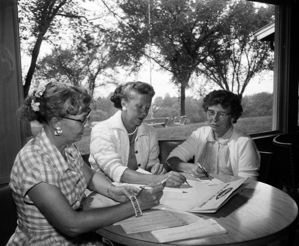 Three of the women in charge of the monthly inter-club golf outings confer at the second round at Blackhawk Country Club. From left are: Eleanor Persons of Maple Bluff, Irene Dettloff of Blackhawk, and Edith Nystrom of Maple Bluff.