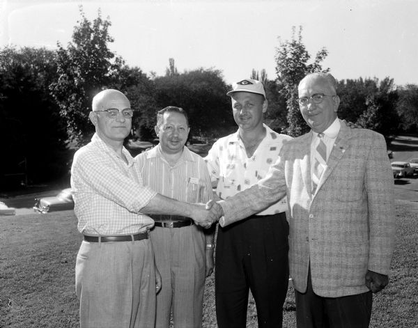 Arthur Pischke of West Bend (right), president of the American Bowling Congress, shakes hands at Nakoma Golf Club. Also shown, left to right are: Les Ogilvie, president of the Madison Bowling Association; Charles Allen, ABC director and jamboree chairman; Danny McCarthy, who carded a 73 at the outing, and Pischke.