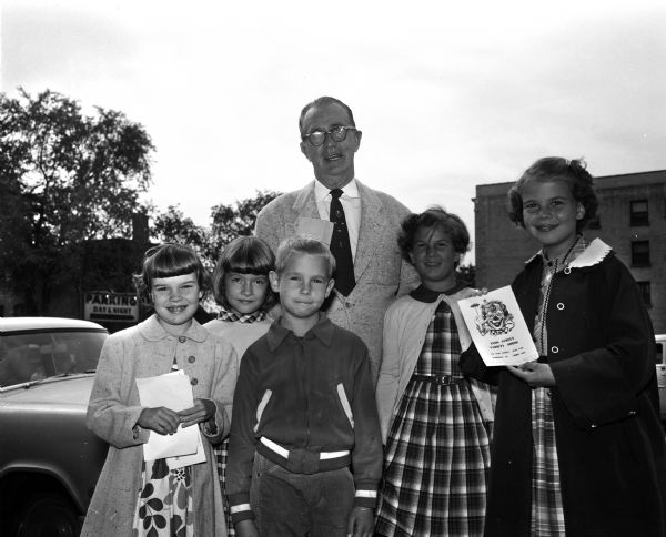 Group portrait of children who presented a variety show and sold popcorn, gum, candy and Kool Aid as a fundraiser for "Roundy's Fun Fund." Shown left to right: Pam Holmes, Conni Berray, Curtis Hossman, Marcia Hossman, and Sue Holmes. Roundy is standing in the background.