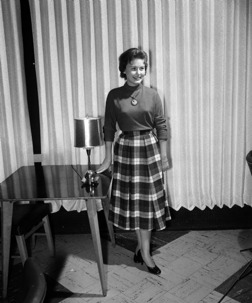 Participating in the Vogue fashion show, designed as a clinic for teenagers who like to sew, is Nancy Pfeiffer, a student at Madison East High School. She models mix and match clothing: a blouse and plaid skirt.
