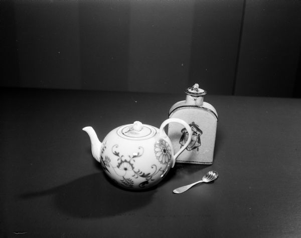 The history of tea service was shown by a display of tea pots in the Wisconsin Historical Society Women's Auxiliary exhibit, "Tides of Taste."  Shown is a small ceramic tea pot, flask, and a spoon.