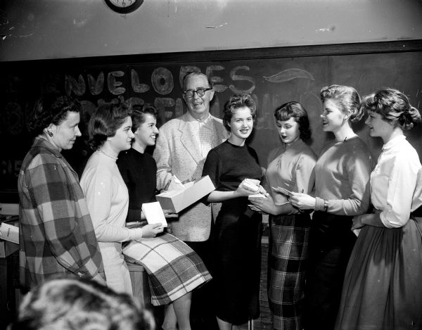 Joseph R. (Roundy) Coughlin poses with members of the Madison West High School girls' club who stuffed envelopes for "Roundy's Fun Fund." The club advisor, Betty Perego, is at left.