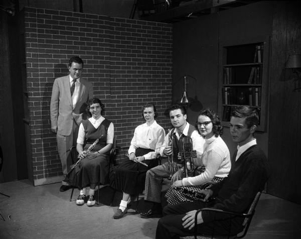 Shown in the WHA-TV studios, left to right, are Professor Robert Monschein; George (?) Kreuzer, oboe; Marilyn Weckel, flute; Doster "Doc" DeHaven and Judith White, trumpets; and David Boyd, clarinet. They are preparing to perform on the weekly TV program, "Toward Understanding" that will trace the development of the symphony orchestra.