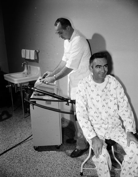 Physical therapist Robert Straelczyk gives a diathermy treatment for spinal arthritis to Swen Auestad, at Lake View Sanatorium, where Mr. Auestad is also a tuberculosis patient.