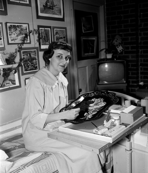 Judy Schroeder of Reedsburg, a patient at Lake View Sanatorium, sits at a desk while painting. While preparing for heart surgery, it was discovered that she also had tuberculosis. She entered Lake View to prepare again for heart surgery. While there, her parents (as well as her roommate's mother) were killed on their way home from a visit to their daughters. Judy, an only child, had successful heart surgery and successful lung surgery, and expects to leave Lake View in about 3 months.