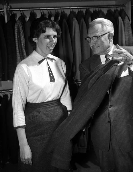 Mary Lou Clingman receiving her prize, a Hart Schaffner & Marx suit, from W.M. Harris, president of Olson & Veerhusen, for winning first prize in a contest to name the new women's suit and coat room in the Olson & Veerhusen store.