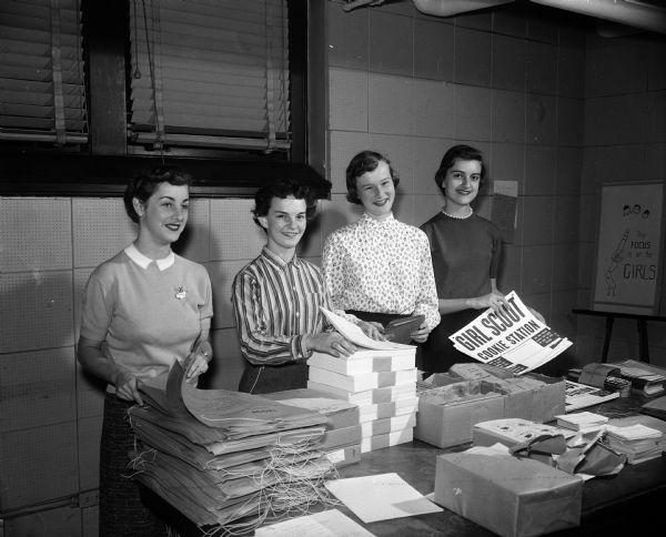Girl Scouts of Mariner Ship Troop 4, Black Hawk Council, pack materials for the cookie sale to be held in 1958. Pictured: Judy Reigle, Nancy Gibson, Anne Nereim, and Judy Taugher.