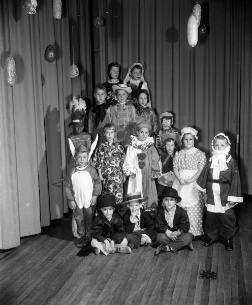 Group portrait of characters in Franklin School first graders' annual Christmas play. Left to right in the picture are: seated: David Mielke, John Colson, Hans Thillman.
First row: Gary Runge, Mona Adams, Kay Christman, John Parisi, Linda Price, Norman Hanson, Barbara Van Kuelen, Jay Hill. Second row: Kenneth Ehle, Terry Peterson; Caniel Imhoff. Top row: Christopher Rodgers, Sandra Schwenn.