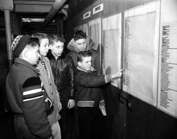 Ace Vines, Curtis Links, Russell Bright, Ronald Woods and David Lythjohan examine the Carrier Efficiency Chart, showing each carrier's efficiency for their overall performance as newspaper carriers. Top carrier boys are rewarded for outstanding performance every three months.