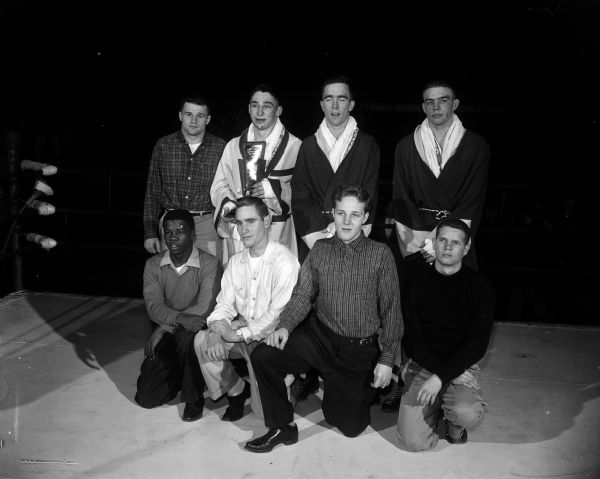Group portrait of eight University of Wisconsin Tournament of Contenders champions. They include, left to right, bottom row: Brown McGhee, Memphis Tenn, 132 lbs.; Ellis Gasser, Portage, 125 lbs.; Wallace DuRose, Gary Ind., 147 lbs.; Mark Heironimus, Madison, 139 lbs. Back row: Bill Hobbs, Eau Claire, 156 lbs.; Bill Urban, Mosinee, heavyweight and winner of "Best Contender" trophy: Bill Sensiba, Green Bay, 178 lbs; and Bob Christopherson Minneapolis, 165 lbs.
