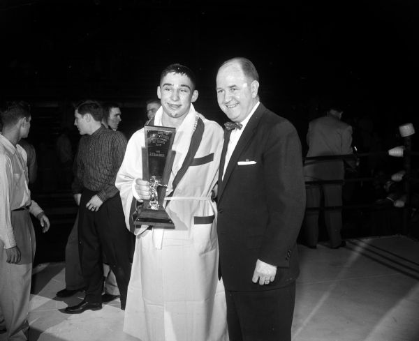 Bill Urban, Mosinee, holds the Best Contender trophy and poses with Coach John Walsh after winning the heavyweight championship at the 24th University of Wisconsin contenders boxing tournament.