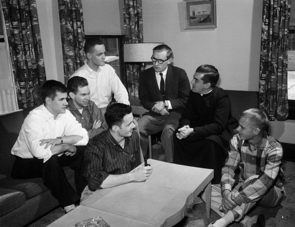 A group of University of Wisconsin students who live at Randall House, 1218 West Dayton Street, a residence established by Catholic institute Opus Dei. Seated on the floor are Robert Kay of West Allis and Dennis Deiscl of Chicago. Others from left to right are: Vance Norum and Michael Lawler, both of Milwaukee; Robert Lotter, Seymour; Peter Dowbar, director and Fr. Gonsala Diaz, chaplain.