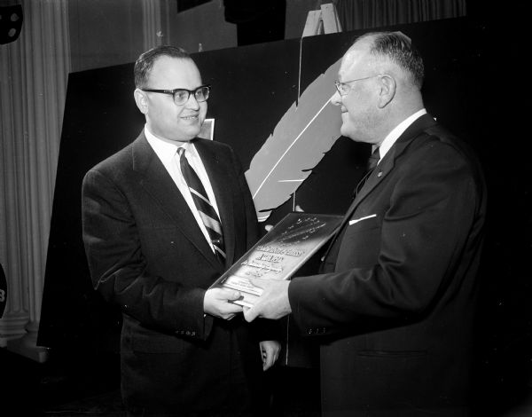 Charles Goulet, 1957 campaign chairman, and Theodore Meloy, 1958 campaign chairman, hold the plaque award at the annual United Community Chest meeting.