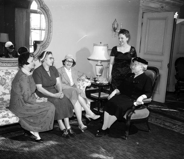 Wisconsin's first lady Mrs. Vernon (Helen) Thomson hosts a tea at the executive residence at 101 Cambridge Road. Among the 200 guests were, left to right, Mrs. Leo Poulson and Mrs. Roy Oleson, Palmyra; Mrs.George (Ruth) Wright, 2448 Van Hise Avenue, whose husband heads Farm and Home Week arrangements; and Frances Zuill, 146 North Prospect Avenue, dean of home economists at the University of Wisconsin. Mrs. Vernon (Helen) Thomson, the hostess, is standing.