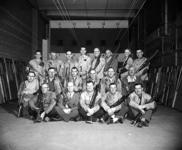 Group portrait of members of the championship Madison rifle club of the Southern Wisconsin Rifle League. The men are shown with their rifles.