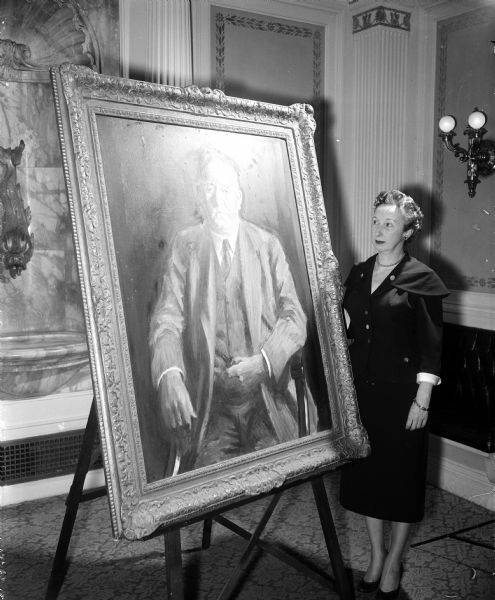 An oil portrait of Gov. Walter S. Goodland is brought out of storage to be hung in the governor's office with those of other former governors. Arlene Weidenkopf, Governor Vernon Thomson's secretary, is examining the painting.