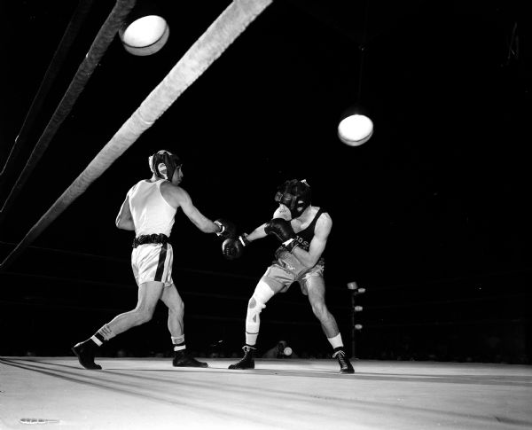 Rollie Nesbit (left), University of Wisconsin boxer, swings right at Dave Nelson of San Jose State in the first round of the 132-pound fight.