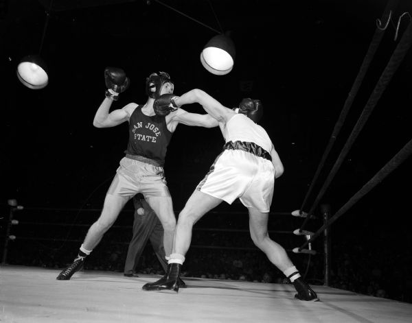 University of Wisconsin boxer Bob Christopherson throws a left hook to the jaw of Ken Christensen of San Jose State in the third round of the 165-pound fight.