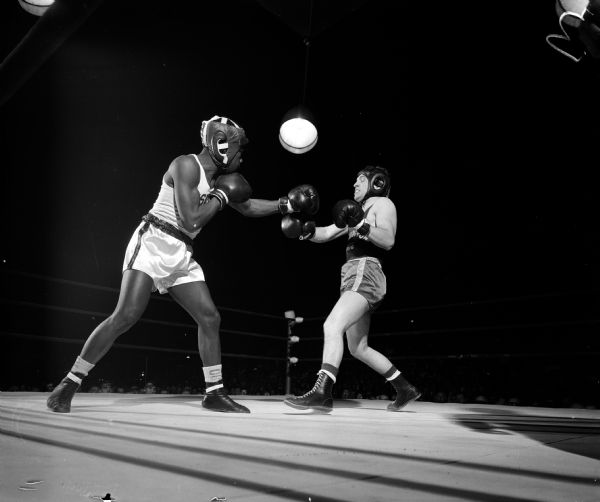 Wisconsin boxer Brown McGhee (left) lands a jab on the jaw of Ron Rall of Washington State during a boxing match between the University of Wisconsin vs. Washington State.