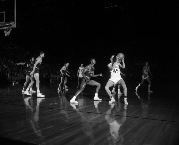 Wisconsin's Steve Radke catches the ball as M.C. Burton of Michigan defends during a basketball game between the University of Wisconsin and Michigan. Wisconsin lost the game.