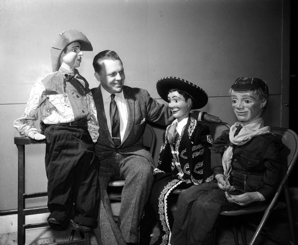 Howard Olson poses as "Chester LeRoy" with three of his wooden puppets: Mr. Zino, Cowboy Eddie, and Sandy McAndy.