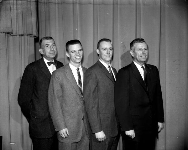 The Madison Gyro club honors players and coaches of the University of Wisconsin basketball team at its 35th annual basketball banquet. Among those taking part were, from left to right, Harold E. (Bud) Foster, Badgers' head coach; Walter (Bunky) Holt, most valuable player; Glenn Borland, captain; and Fred (Fritz) Wegner, assistant coach.