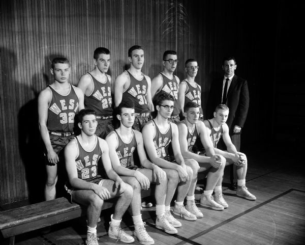 Group portrait of the Madison West High School basketball team. Seated, left to right, Howard Mazur, Tom Doran, Bill Workman, Fritz Kruger, and Jim Bakken. Back row, left to right, Paul Hathaway, Fred Heivilin, Tom Harrington, Jim Grieger, Roger Wiebe, and coach Jim Stevens.