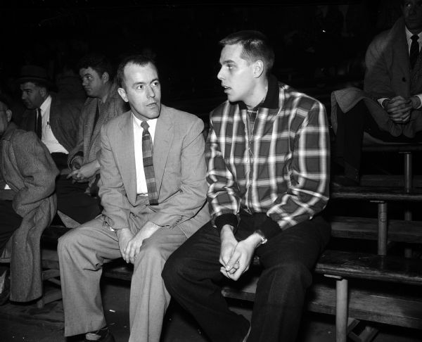 Coach Harry Gibbs, Eau Claire High School coach of the Old Abes basketball team, talks with Bob Barneson, forward on the University of Wisconsin basketball team.  Barneson played basketball while at the high school in Eau Claire, Wisconsin.