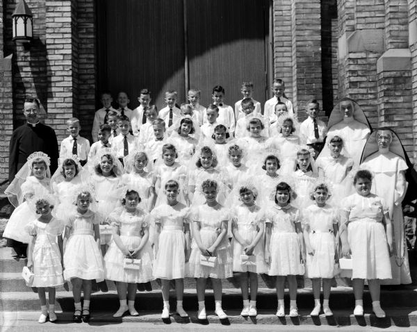 The first communion class of children on the steps of St. Patrick's church, 410 East Main Street.