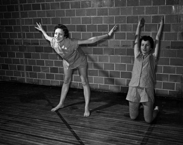 Francie Hauptman (left) and Dorothy Hughes (right) do warm-up exercises to prepare for dance class at East High School.