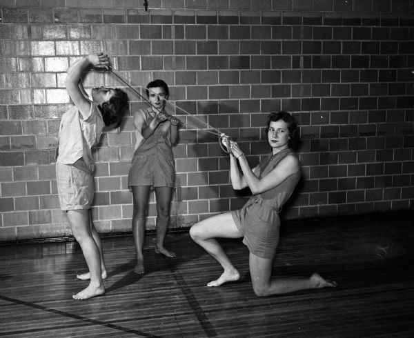 Left to right: Jane Nedderman, Mary Jane Heidt, and Pat Kernan shown with rope as a prop in modern dance class at East High School.