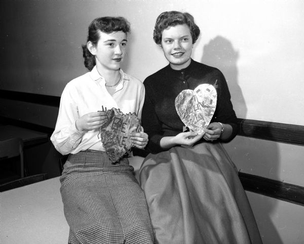 Connie Platz (left) and Mary Hess (right), decorations chairman and social chairman, prepare for West High School's Valentine dance.