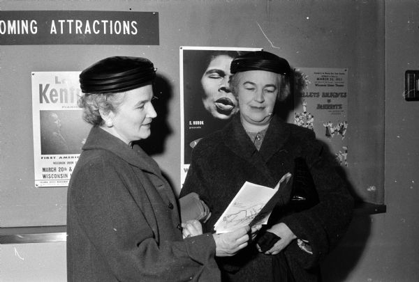Two sisters from Mauston, Mrs. Thomas Shelton, left, and Mrs. William T. Walsh, consulting a program for the annual University of Wisconsin Farm and Home Week.