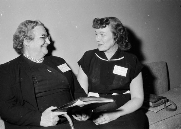 Mrs. Jessie Avery (left) chatting with Mrs. Verle Jacobs, both members of the Dane County Homemakers. The women sang with the Homemaker's Chorus during the annual University of Wisconsin's Farm and Home Week.