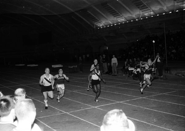 Don Hebein of the University of Wisconsin, right, races across the finish line first in the 60-yard dash during Saturday's triangular track meet against Northwestern and Iowa.