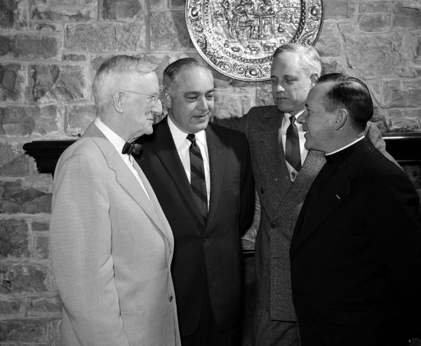 Four members of the Military Order of the World Wars swap tales about their former days in military service at a Madison Chapter cocktail and dinner meeting. Left to right: Capt. Harrison L. Garner, Capt. William R. Curkeet Jr., Col. Carl Flom, and Major (Chaplain) Austin J. Henry.