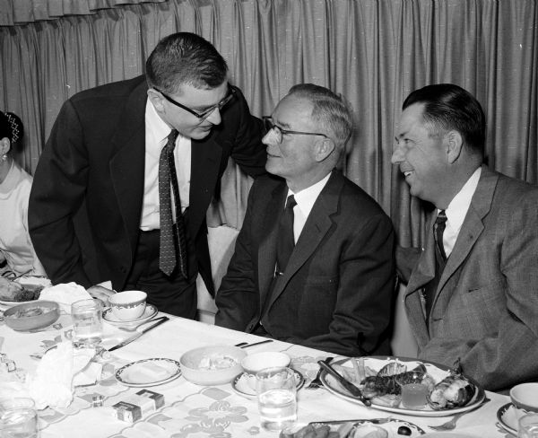 William E. Brobst, center, master of ceremonies, at a farewell dinner for 20 members of the Pure Oil Co. Madison office who are leaving the company or are being transferred. Left is John Augustine and right is Howard W. Brown.